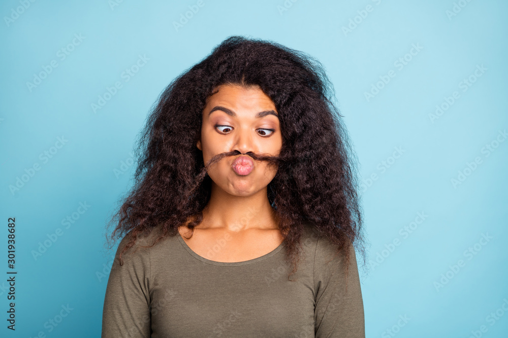 Close up photo of childish playful afro american girl with fake mustache  look joking fooling feel crazy funny funky wear green casual style clothing  isolated over blue color background Stock Photo |
