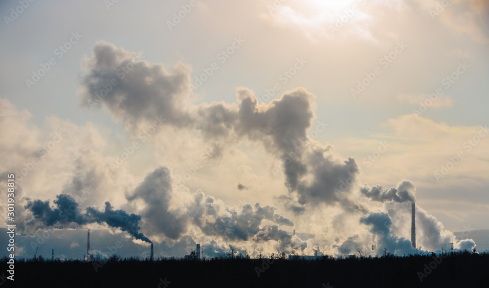 Factory chimneys pollute the atmosphere with dense smoke.