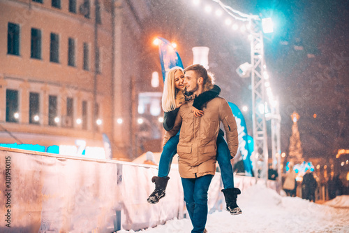 Cheerful and playful couple in warm winter outfits are fooling around