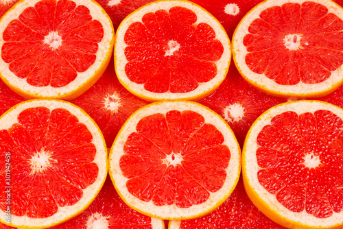 Grapefruit red juicy slices background. top view