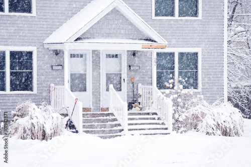 a small cozy house covered with snow during the snowfall. The atmosphere of winter comfort and weather. photo