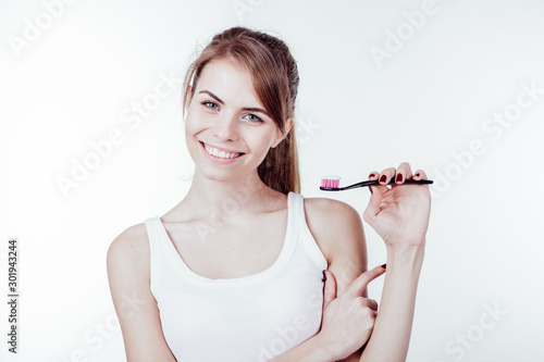 girl with white teeth smiles shows the toothbrush photo