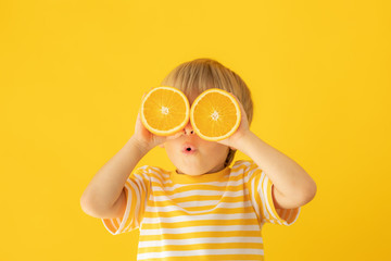 Happy child holding orange
