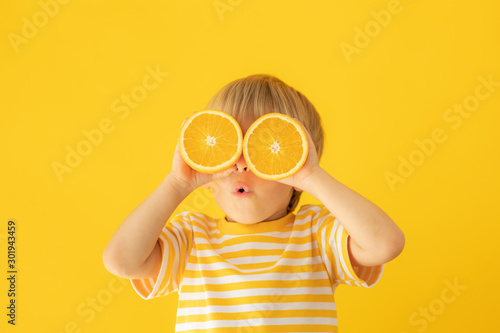 Canvastavla Happy child holding orange