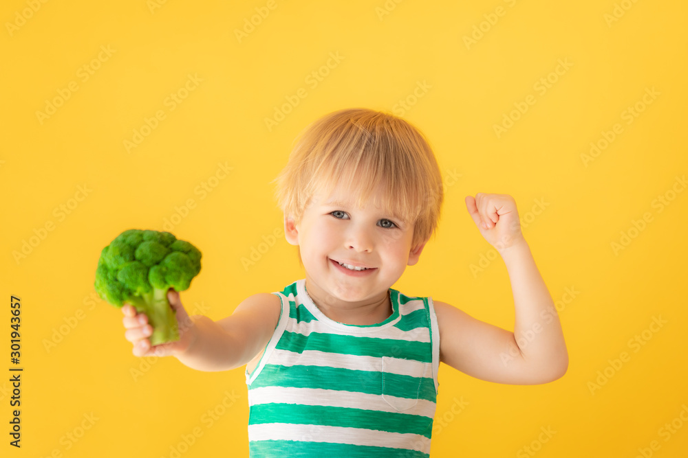 Strong child holding broccoli