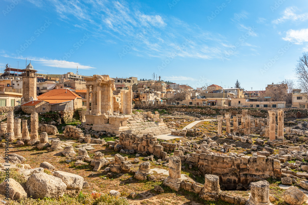 The ruins and only fragment of Venus temple left with modern houses and blue sky in the background, Beqaa Valley, Baalbeck, Lebanon