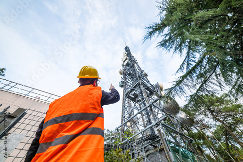 Bild auf Leinwand Ingegnere delle telecomunicazioni con nuova antenna telefonica 5G in montagna per internet
