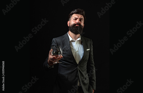 Businessman gets rid of stress with cognac. Bearded businessman in elegant suit with glass of cognac. Man Bartender holding glass of cognac.