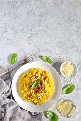 Traditional Italian risotto with mushrooms, saffron and parmesan cheese. Top view with copy space.