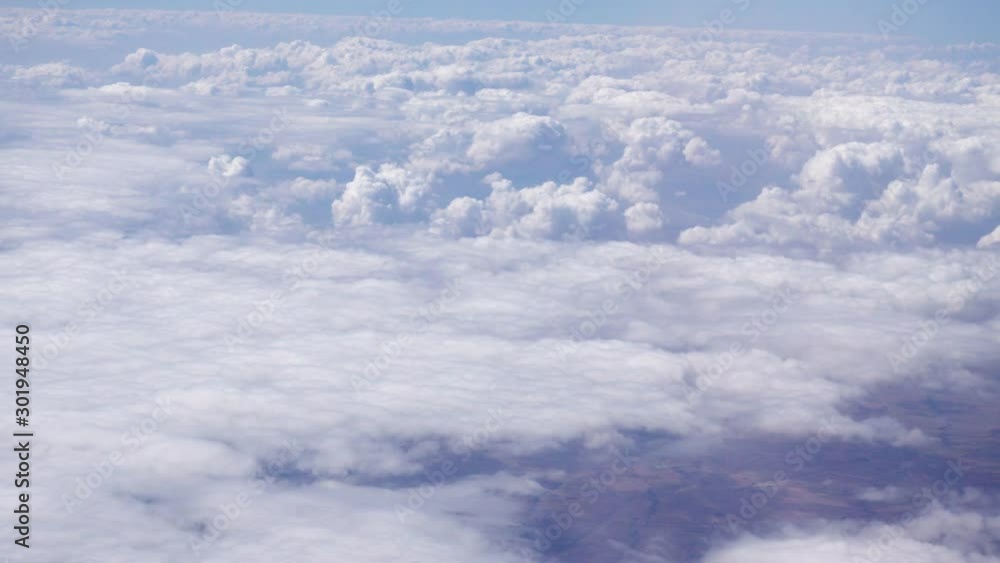 View of dense white clouds seen from the window of a passenger plane View of dense white clouds seen from the window of a passenger plane