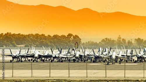 Fotografie military fighter jet storage facility at airport against mountain landscape background on sunset