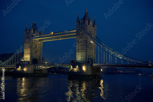 Scenic evening view of Tower Bridge with lights reflecting on the River Thames in London  UK