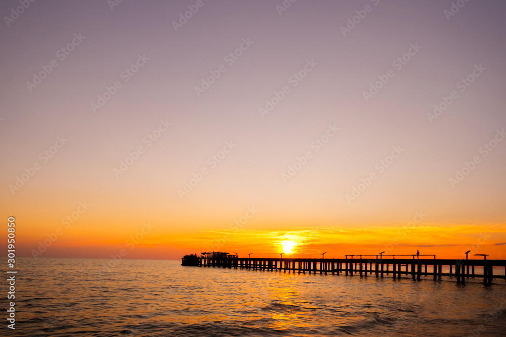 Sunset sky on the bridge at sea beach ocean.