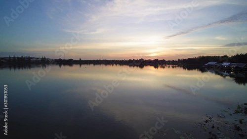 Wallpaper Mural Vdo. Aerial view evening above reservoir around with green tree and yellow sun ling in cloudy sky background, sunset at Krajub reservoir, Nong Kob, Ban Pong, Ratchaburi, Thailand. Torontodigital.ca