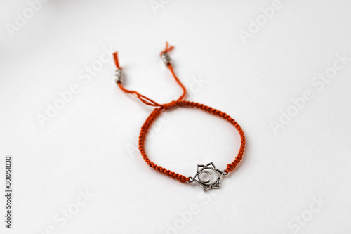 orange braded bracelet with chakra (svadhishthana) on white background photo