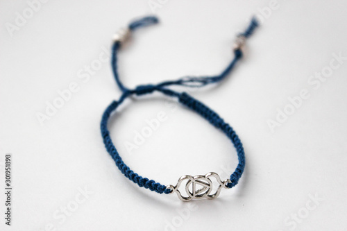 blue braded bracelet with chakra (ajna) on white background