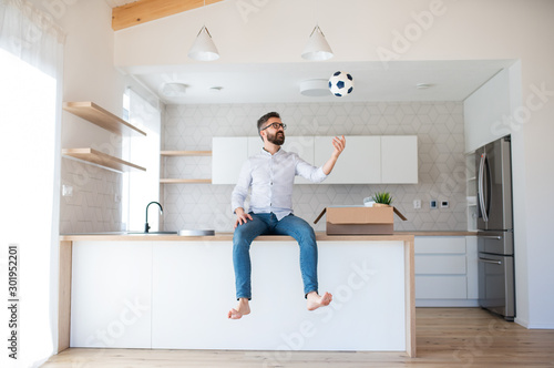 Mature man with boxes moving in new unfurnished house.