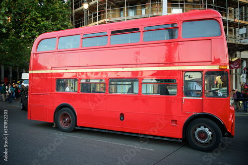 Classic red double-decker Routemaster bus passing on a London, UK street