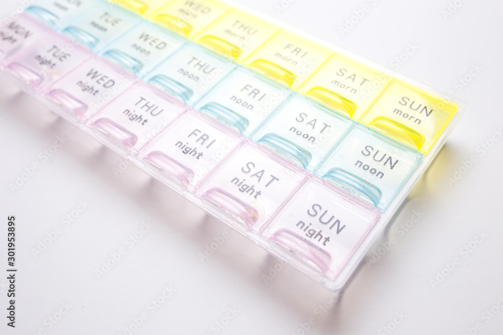 Organizer for medical pills on a white isolated background close-up. Organization of taking pills of the day. Organizer for medical pills on a white isolated background close-up. Organization of taking pills of the day.