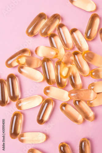 Close up vitamin C capsules on pink isolated background.