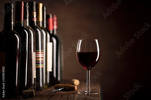 Red Wine in glass and bottles on a dark background with copy space