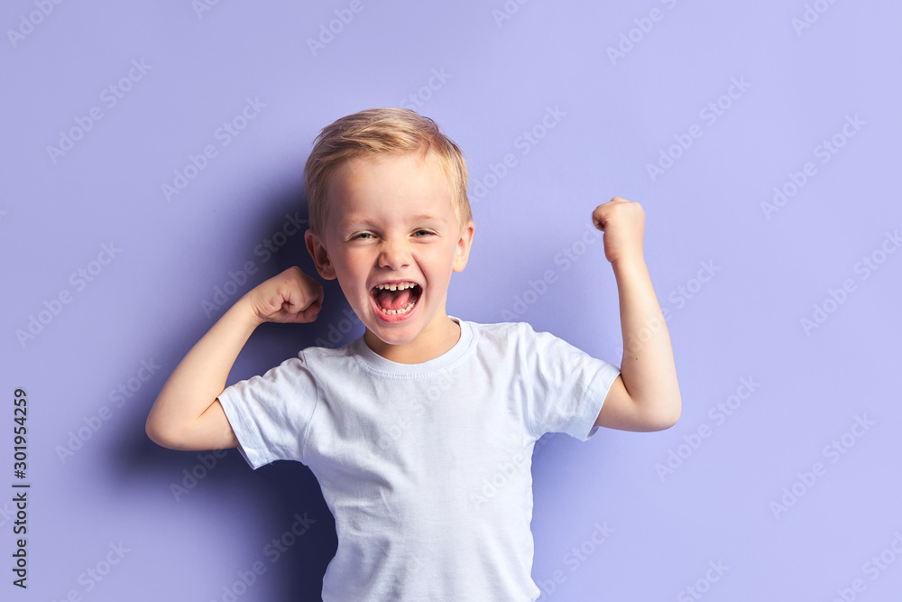 Emotional little boy full of happy feelings. Portrait, isolated over purple background - obrazy, fototapety, plakaty 