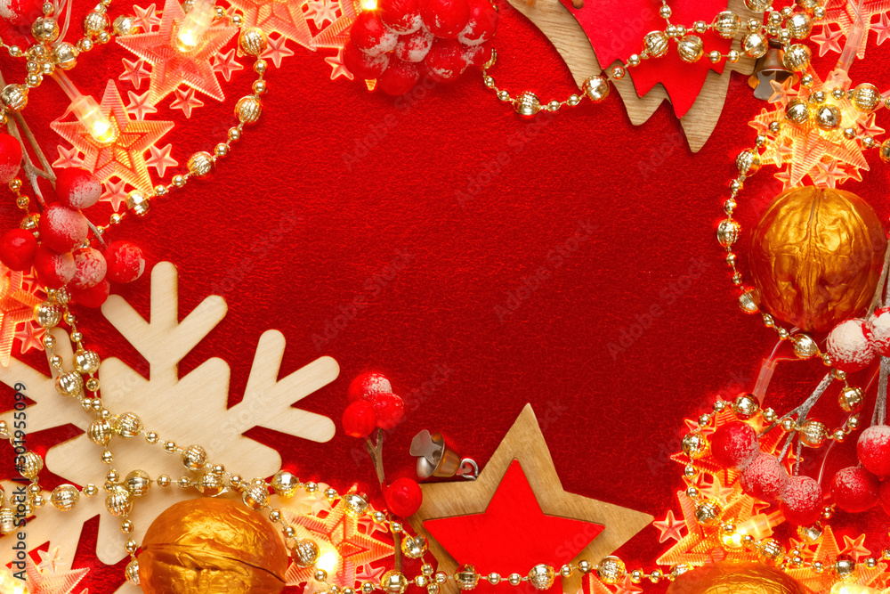 Red and gold background with christmas decorations and garlands. Abstract Xmas pattern. Shining golden beads and a yellow garland in the shape of stars are laid out on new year's ornate. Flat lay.