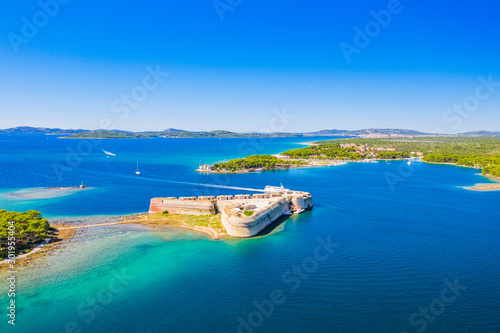 Fototapeta Naklejka Na Ścianę i Meble -  Saint Nicholas fortress and Jadrija town at Sibenik bay entrance, Dalmatia, Croatia, drone aerial shot of beautiful blue coastline seascape