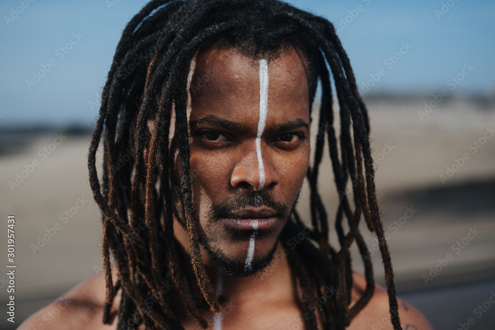 Outdoor emotional Fashion Portrait of African man wearing long dreadlocks  and fancy makeup white face paint Stock Photo