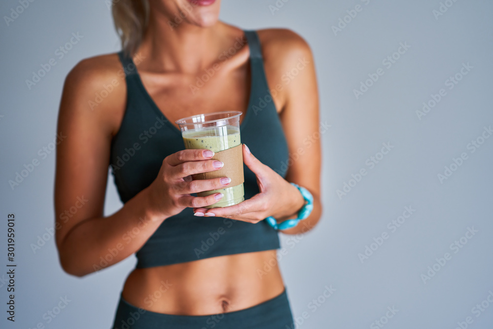 Adult woman drinking healthy smoothie after workout Adult woman drinking healthy smoothie after workout