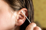 Woman cleaning ear with cotton swab. Hygiene ears.
