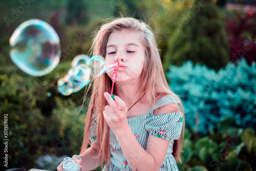 beautiful little girl child. Outdoors, blowing bubbles. Children's lifestyle