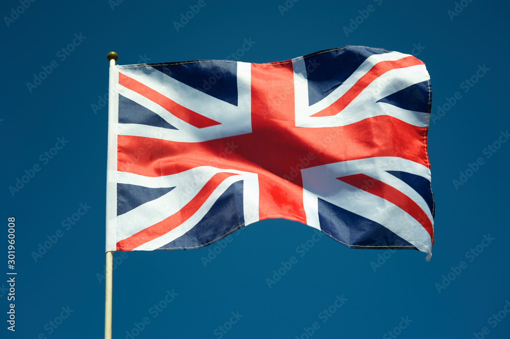 Single British Union Jack flag flying on a flag pole in sunny bright blue  sky Stock Photo | Adobe Stock