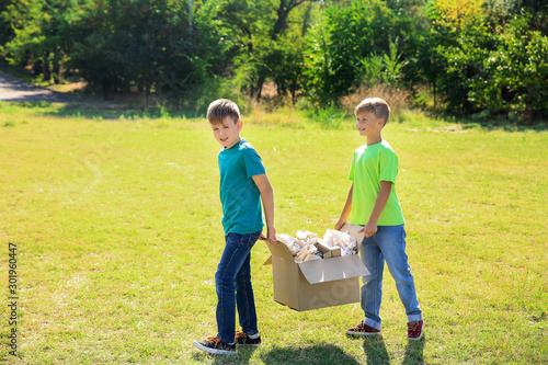 Boys gathering garbage outdoors. Concept of recycling