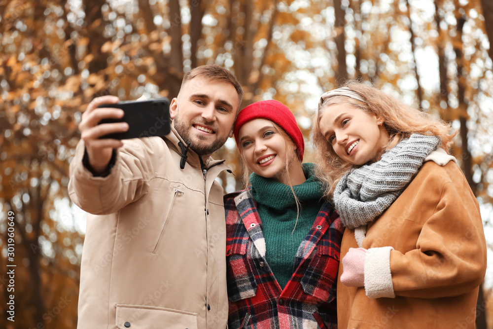 Friends taking selfie in autumn park