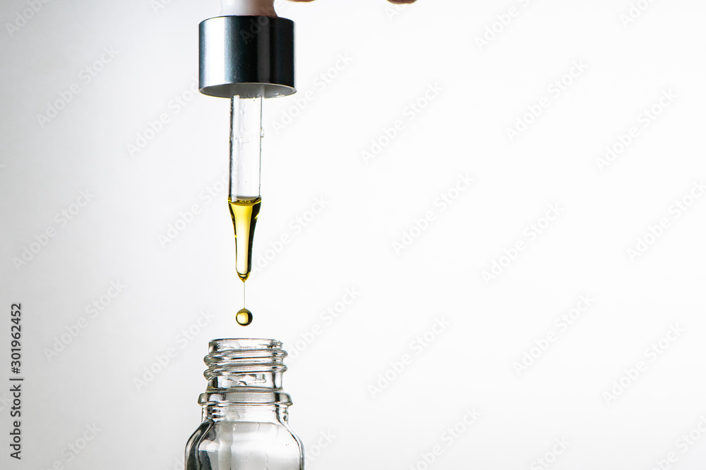 Glass bottle with dropper. Studio. Medical cannabis, essential oils or anti aging serum concept Glass bottle with dropper. Studio. Medical cannabis, essential oils or anti aging serum concept