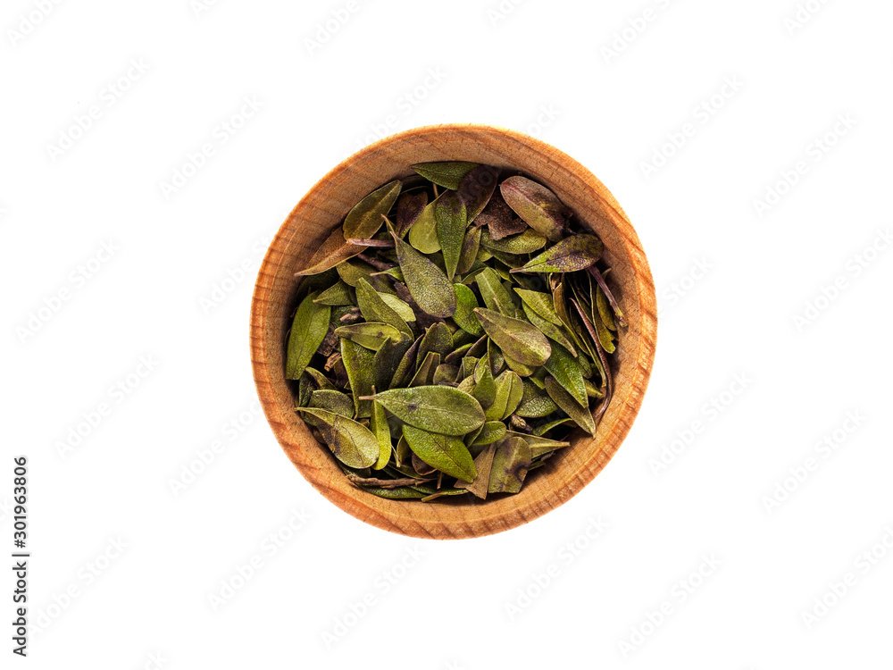 Dry leaves of Arctostaphylos in a wooden Cup on a white background Dry leaves of Arctostaphylos in a wooden Cup on a white background