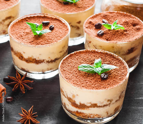 Tiramisu in the glass decorated whith mint on the wooden background