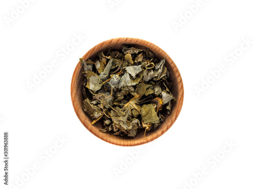Dry Chelidonium in wooden Cup on white background