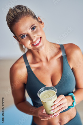Adult woman drinking healthy smoothie after workout
