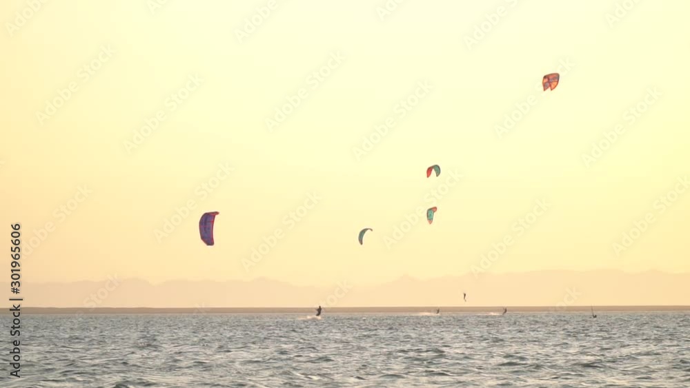 Kitesurfers in the sea are riding the wind and gliding, extreme water sport Kitesurfers in the sea are riding the wind and gliding, extreme water sport