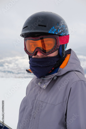 Young snowboarder riding in the mountains on a snowboard. © evelinphoto