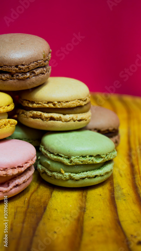 Colored macarons isolated on wooden dish, typical French dish