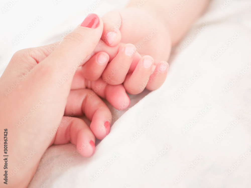 Mom holds the hand of a newborn baby. Close-up. A place to write. Placing text. defocusing. Baby's hand holding finger to mom. Mom holds the hand of a newborn baby. Close-up. A place to write. Placing text. defocusing. Baby's hand holding finger to mom.
