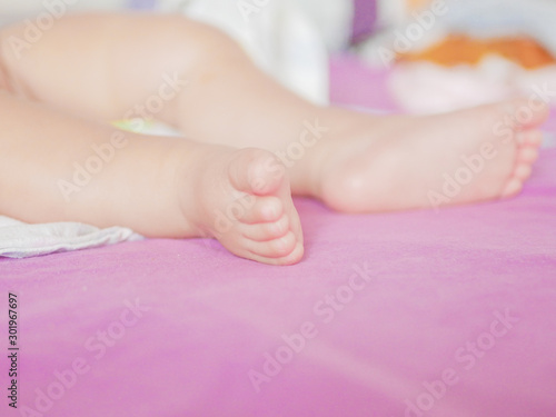 Children's feet. Looks from a knitted pastel blanket. Close-up. A place to write. Placing text. defocus