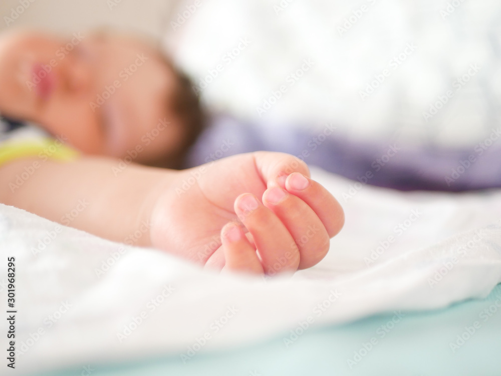 Childrens daytime sleep. Funny baby sleeping on the back of the bed at home. Children's day position. Healthy sleep. Arms outstretched during sleep Childrens daytime sleep. Funny baby sleeping on the back of the bed at home. Children's day position. Healthy sleep. Arms outstretched during sleep