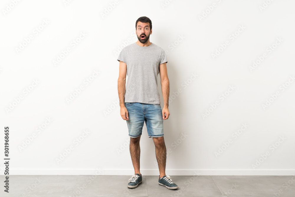A full-length shot of handsome man with beard with surprise facial expression A full-length shot of handsome man with beard with surprise facial expression