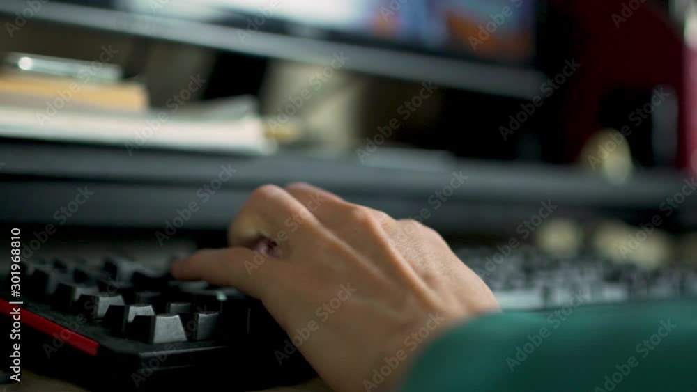 Close-up of a hand on the keyboard of a guy gamer playing an online video game on his personal computer. Close-up of a hand on the keyboard of a guy gamer playing an online video game on his personal computer.