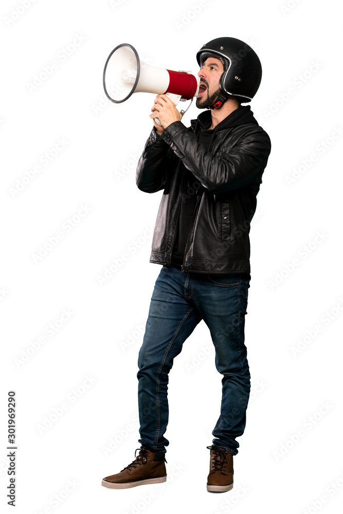Full-length shot of Biker man shouting through a megaphone over isolated white background Full-length shot of Biker man shouting through a megaphone over isolated white background