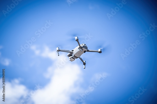 Fototapeta Naklejka Na Ścianę i Meble -  Gray drone flies against the sky with clouds